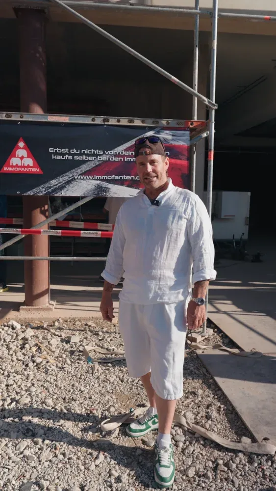 Vor dem Immofanten-Banner auf der Baustelle